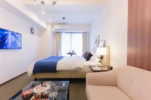 a hotel room with a bed and a couch at LEOPARD Shinsaibashi in Osaka
