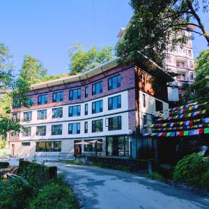 un edificio con banderas delante en Indra Mandala,Gangtok - AM Hotel Kollection en Gangtok
