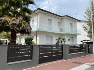 una casa blanca con una puerta negra y una palmera en Exclusive Home 2, en Misano Adriatico
