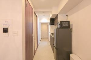 a hallway with a refrigerator in a room at LEOPARD Shinsaibashi in Osaka