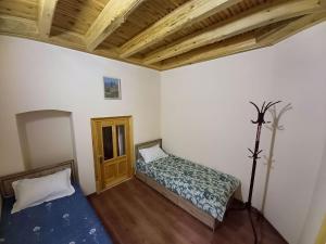 um quarto com uma cama e piso em madeira em Rassom Hostel em Samarkand