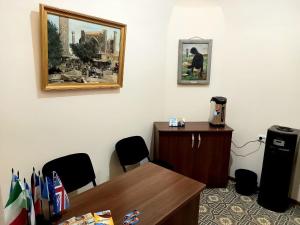 um escritório com uma secretária e uma foto na parede em Rassom Hostel em Samarkand