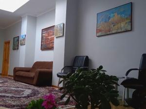 a living room with a couch and chairs and a plant at Rassom Hostel in Samarkand