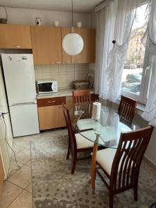 cocina con mesa, sillas y nevera en Apartman Harmani, en Bihać