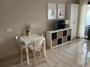 a dining room with a table and chairs and a television at Departamento Ingrid in Puerto del Carmen