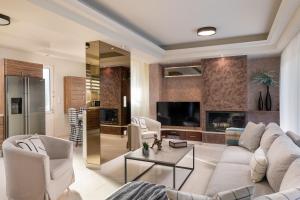 a living room with white furniture and a fireplace at Emmelia Villa in Ialyssos