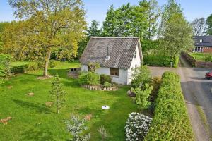 een klein wit huis midden in een tuin bij Holiday House Billundvej 74 in Randbøl