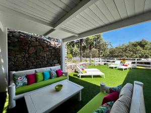 patio con sofá y pared de piedra en Palmasera Bed & Breakfast, en Cala Gonone