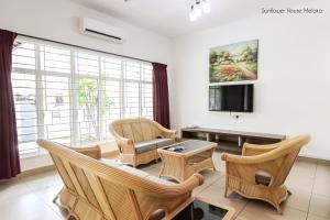 uma sala de estar com cadeiras, um sofá e uma televisão em De Harmony Stay em Malaca