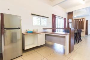 a kitchen with a refrigerator and a counter top at De Harmony Stay in Malacca