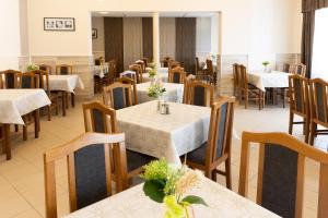 a dining room with white tables and chairs and tablesearcher at Napfény Hotel in Zalakaros