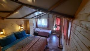 1 dormitorio con 2 camas en una cabaña de madera en Özen Boyabağı en Kösedere