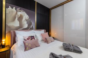 1 dormitorio con 1 cama con sábanas blancas y almohadas rosas en Skywalker Royal en Dubrovnik