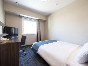 una camera d'albergo con letto e TV di Hotel Villa Fontaine Tokyo-Kudanshita a Tokyo