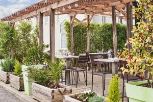 un patio avec des tables, des chaises et des plantes dans l'établissement Campanile Valence Nord - Bourg-Les-Valence, à Bourg-lès-Valence