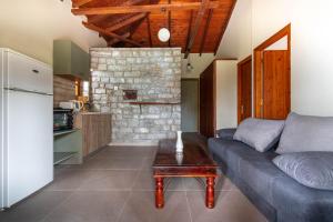 a living room with a couch and a table at Porto Kalamitsi Stone-built Bungalows in Kardamili