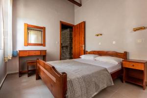 a bedroom with a bed and two night stands and a window at Porto Kalamitsi Stone-built Bungalows in Kardamili