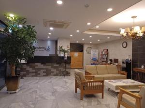 um lobby de uma loja com um sofá e cadeiras em SH Jungmoon City Stay em Seogwipo