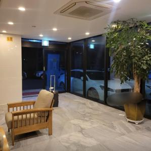 a lobby with a chair and a car dealership at SH Jungmoon City Stay in Seogwipo