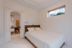 Dormitorio blanco con cama y mesa en Stay Arum Samdal en Seogwipo