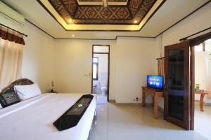 a bedroom with a bed and a tv on a ceiling at SUARA SIDHI Villa Ubud Bali in Ubud