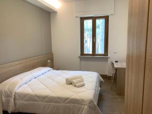 a bedroom with a bed and a desk and a window at San Giuseppe Casa per Ferie in Quercianella