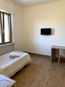 a bedroom with a bed and a tv on the wall at San Giuseppe Casa per Ferie in Quercianella