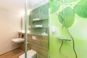 a bathroom with a shower with a toilet and a sink at Hotel Waldmühle in Zella-Mehlis
