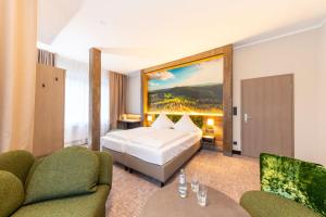 una stanza d'albergo con un letto e due sedie di Hotel Waldmühle a Zella-Mehlis Altre 37 foto