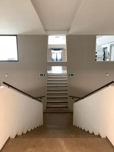 a hallway with white walls and stairs in a building at San Giuseppe Casa per Ferie in Quercianella