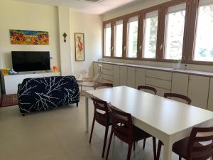 a living room with a table and chairs and a television at San Giuseppe Casa per Ferie in Quercianella