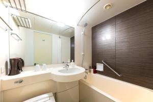 a bathroom with a sink and a mirror and a tub at Hotel Villa Fontaine Tokyo-Kudanshita in Tokyo +14 photos
