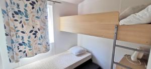 a small room with a bunk bed and a window at locationestivale40 Bungalow petit budget océan forêt in Bias