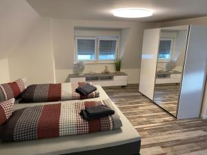1 Schlafzimmer mit 2 Betten und einem Spiegel in der Unterkunft Ermmes Ferienwohnungen in Sinsheim