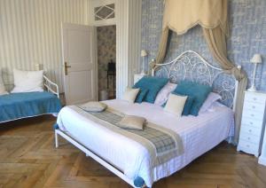 マザメにあるMaison d'hôtes "Les Jardins de Mazamet"の青と白のベッドルーム(大型ベッド1台付)