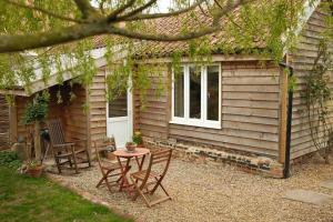 a table and chairs in front of a house at Mustard Pot Cottage in Eye