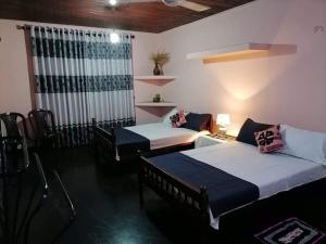 pokój z 2 łóżkami i kanapą w obiekcie Kingsland Hostel w mieście Anuradhapura