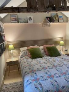 a bedroom with a bed and a table with two lamps at Mustard Pot Cottage in Eye