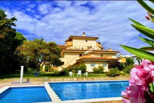 una villa con piscina frente a una casa en Apartamentos Stil Mar Anna - Stil Mar Anna L'Escala 4, en L'Escala
