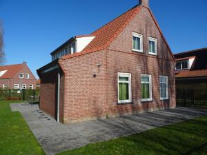 a red brick house with a red roof at Kustverhuur, Landgoed de Lente in Breskens