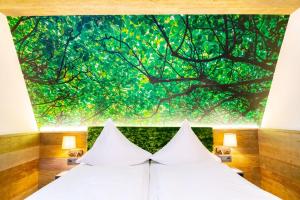Hotel Waldmühle في تسيلا-ميليس: غرفة نوم بسرير ابيض مع لوحة على الحائط