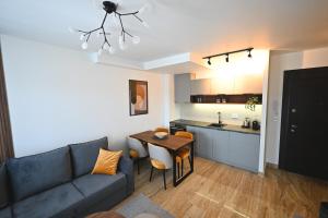 uma sala de estar com um sofá, uma mesa e uma cozinha em Tasa Apartmani em Zlatibor