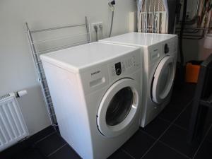 een witte wasmachine en droger in de kamer bij Kustverhuur, Landgoed de Lente in Breskens