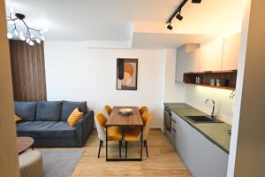 a kitchen and living room with a table and a couch at Tasa Apartmani in Zlatibor