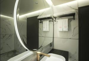 済州市にあるSH Amber City Stayのバスルーム(鏡、洗面台、トイレ付)