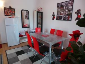 a dining room with a table and red chairs at 2 L in Jablanac