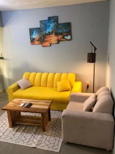 a living room with a yellow couch and a coffee table at Appart F2 plein centre 