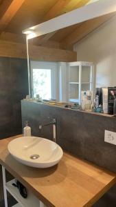 La salle de bains est pourvue d'un lavabo blanc sur un comptoir en bois. dans l'établissement Terrace Vista Interlaken, à Interlaken