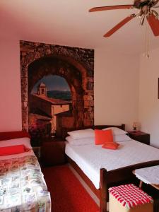 a bedroom with two beds and a stone wall at 2 L in Jablanac