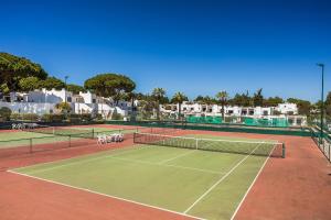 a tennis court with chairs and a net at Apartament Portes Balaia in Albufeira